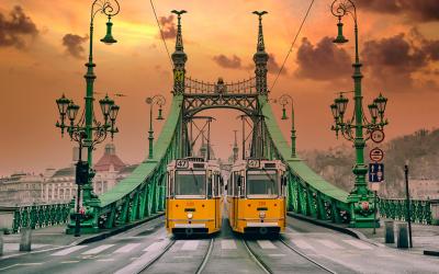 Two old yellows trams on the Liberty Bridge in Budapest. Architecture of Art Nouveau style.